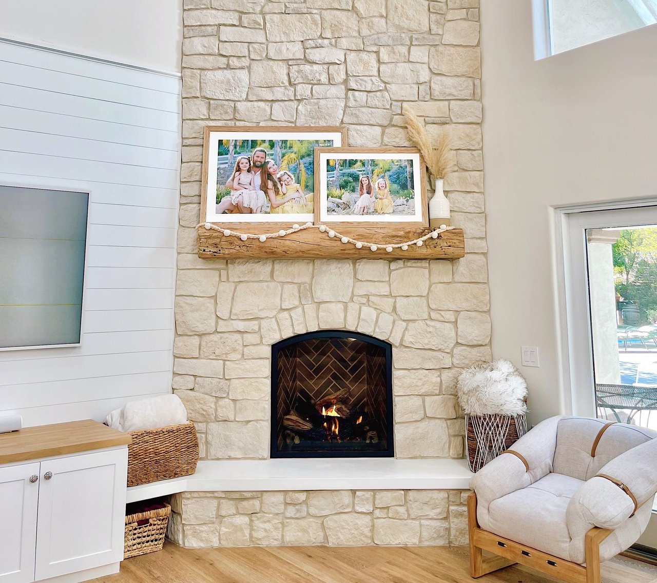 framed photos above the fireplace in a sunny home
